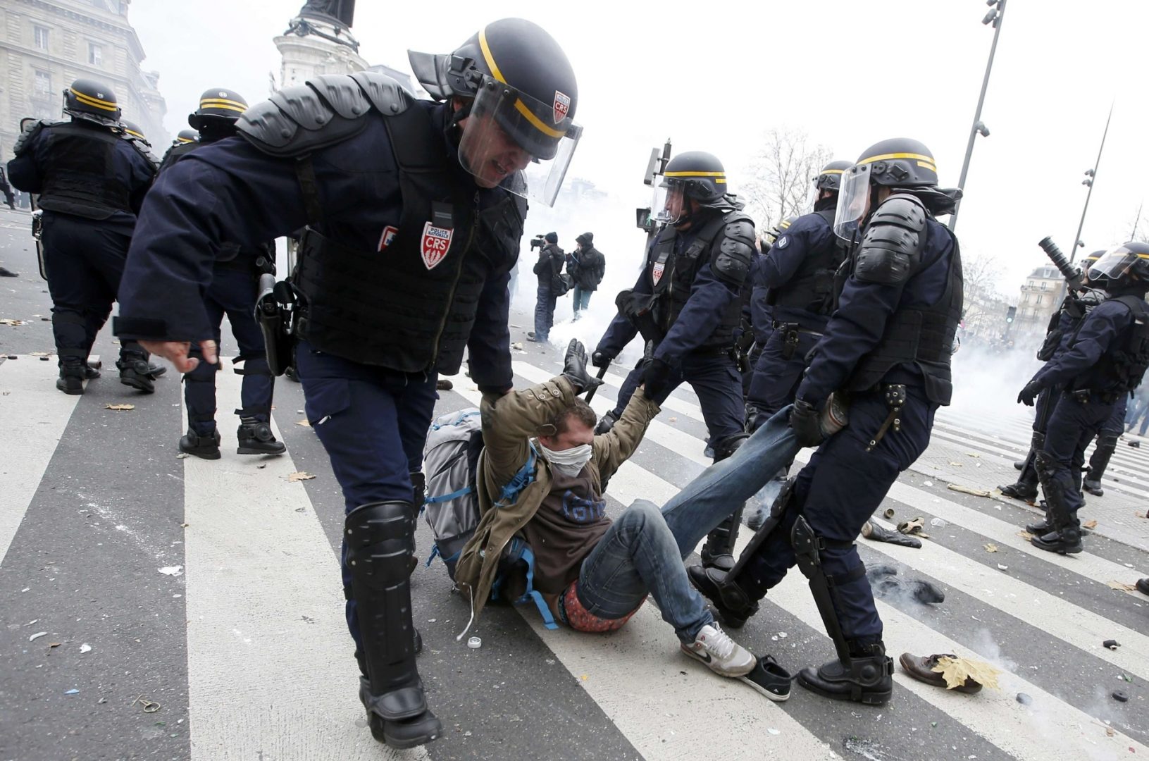French CRS riot police apprehend a demonstrator during clashes near the Place de la Republique after the cancellation of a planned climate march following shootings in the French capital, ahead of the World Climate Change Conference 2015 (COP21), in Paris, France, November 29, 2015.          REUTERS/Eric Gaillard   TPX IMAGES OF THE DAY
