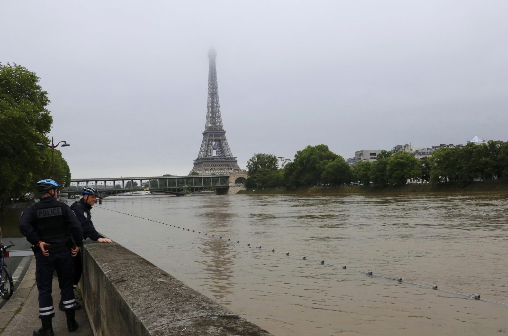 French police stop to look at flooding on the banks of the Seine River near the Eiffel Tower after days of heavy rainfall in Paris, France, June 2, 2016. REUTERS/Jacky Naegelen
