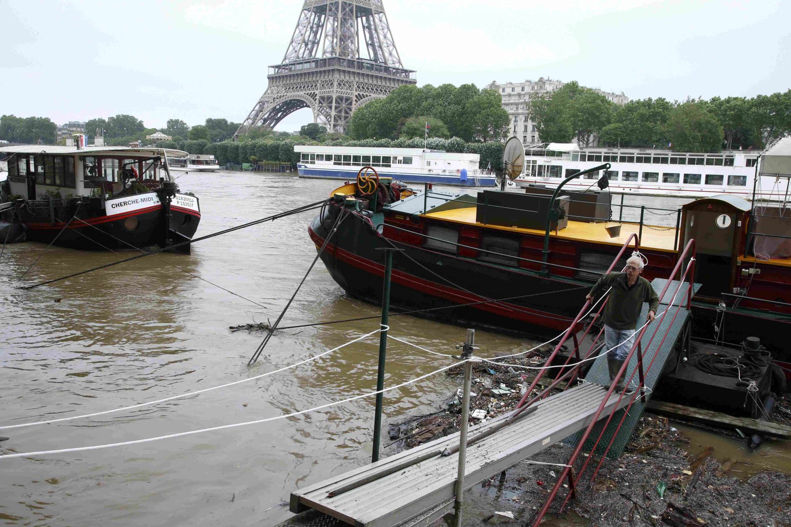 A man uses a footbridge as he leaves his houseboat moored near the Eiffel tower during flooding on the banks of the Seine River in Paris, France, after days of almost non-stop rain caused flooding in the country, June 2, 2016. REUTERS/Pascal Rossignol