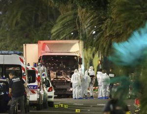 French police forces and forensic officers stand next to a truck that ran into a crowd celebrating the Bastille Day national holiday on the Promenade des Anglais killing at least 60 people in Nice