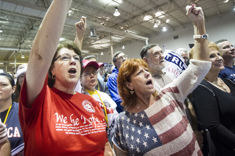 Supporters Claudia Sanchez, left, and Irish Lyn Murphy, right, both from Woodstock, Ga., cheer on Republican presidential candidate Donald Trump during a campaign rally at the North Atlanta Trade Center, Saturday, Oct., 10, 2015, in Norcross, Ga. (AP Photo/John Amis)